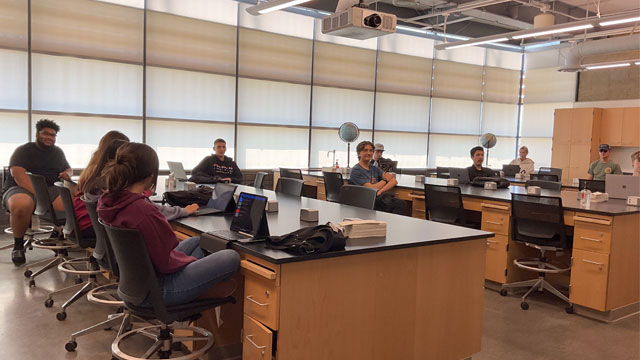 Malibu campus science room with students sitting in chairs looking at the camera