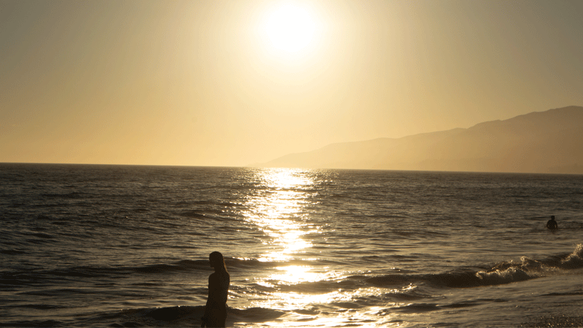 Sunset at Westward Beach, Malibu. Photo of woman looking at the ocean at sun down.