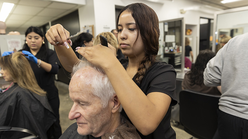 Student trimming a client's hair.