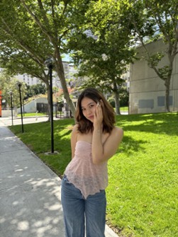 student posing in front of grass